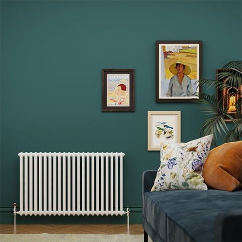 White windsor column radiator against a green wall in a sitting room
